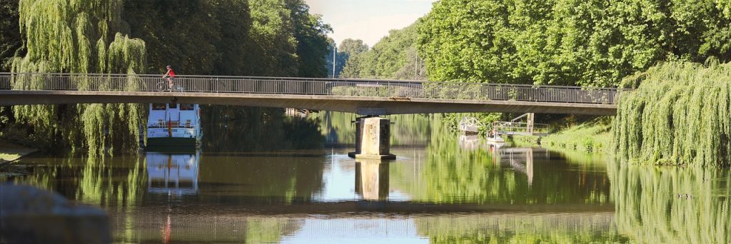 Radfahrer auf Brücke über Fluss